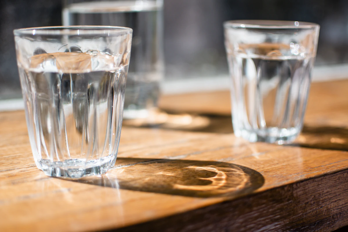 Two glasses of clean water on a wooden table